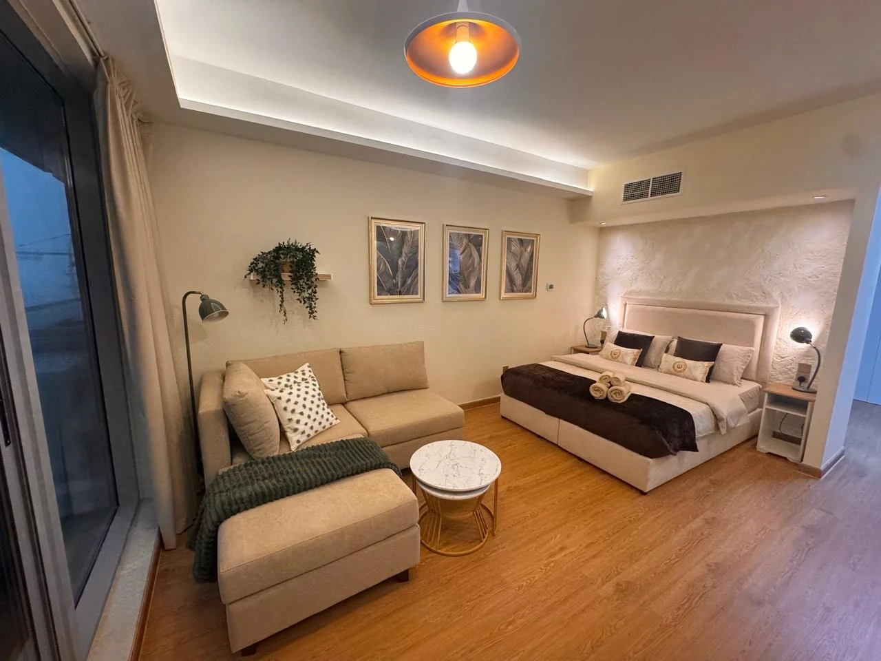 Another Donna Branka studio: a textured feature wall, framed botanical prints, warm lamps and a marble side table.